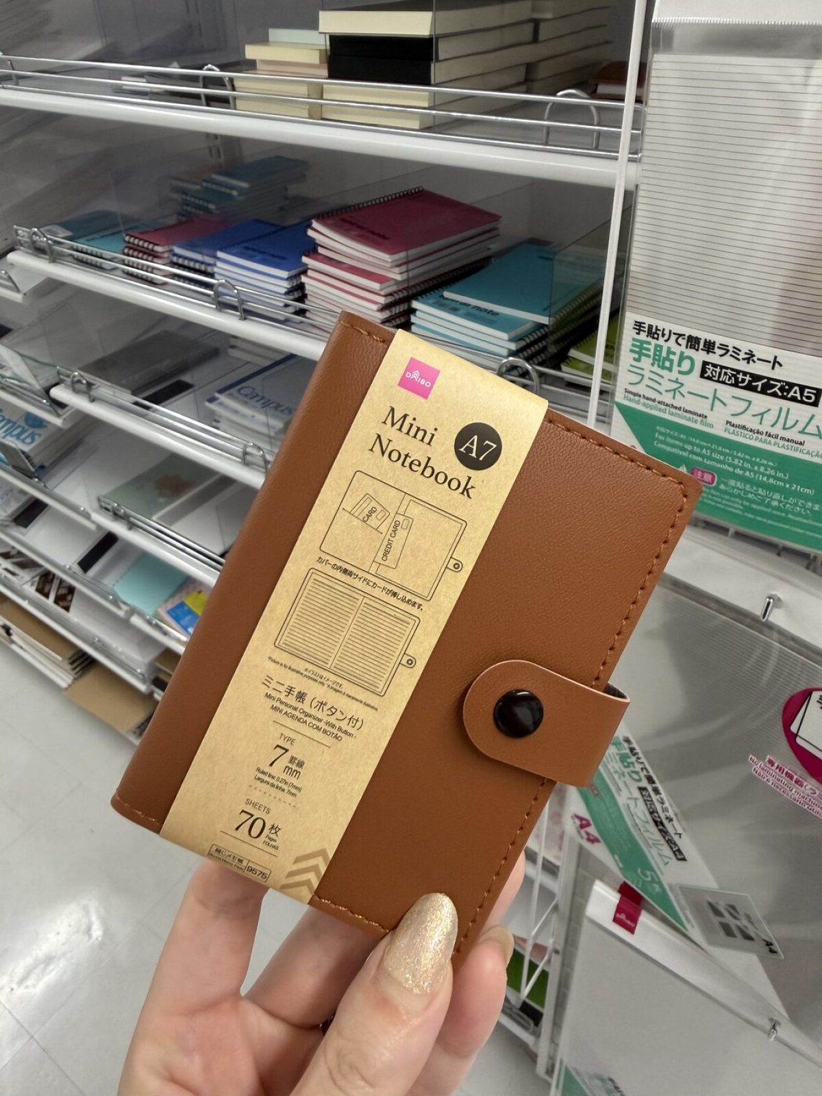 A7 pocket notebook with a leather-look cover and press stud at DAISO