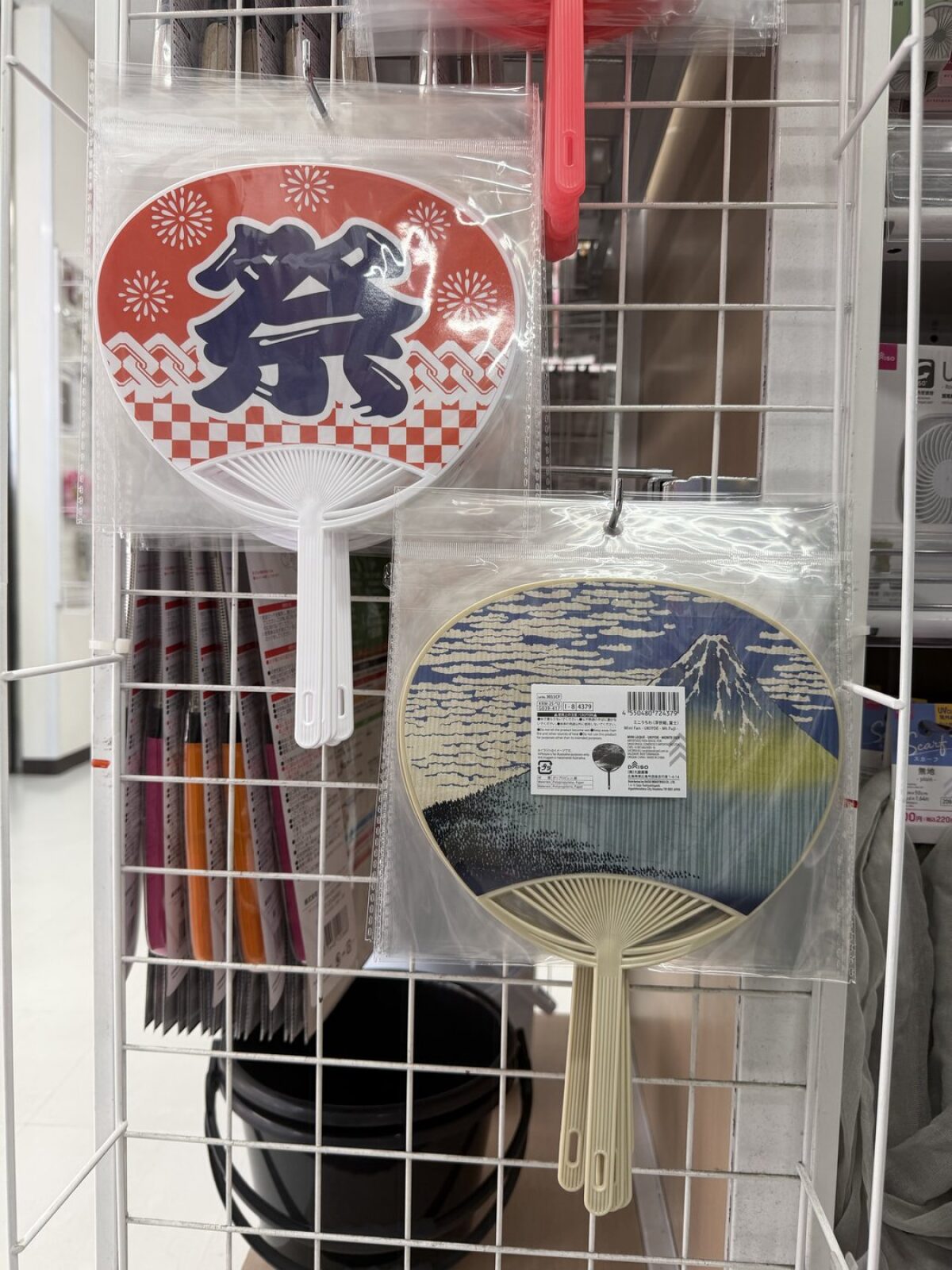 Two Japanese uchiwa paddle fans at DAISO, one festival print and one Hokusai wave