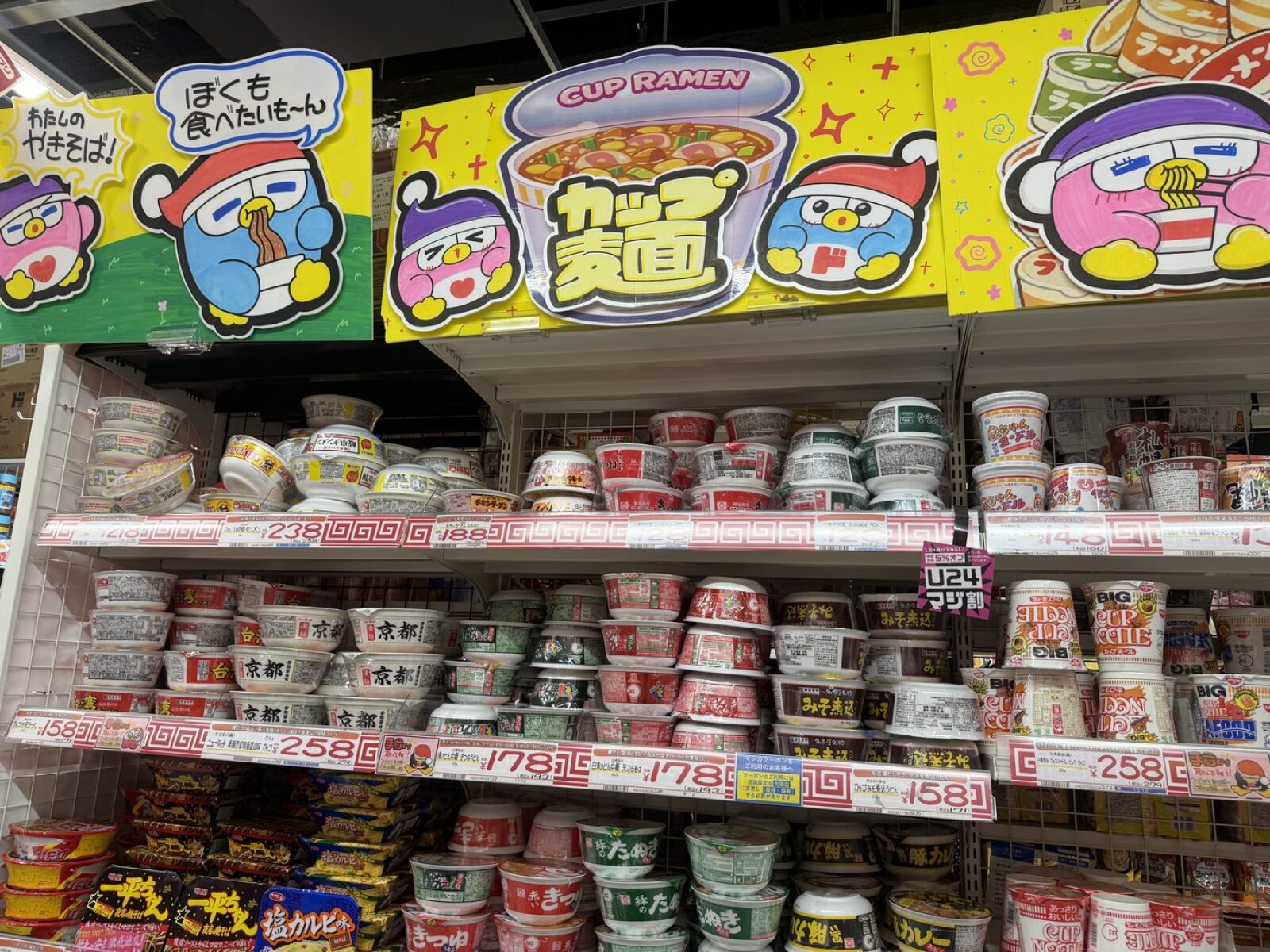 Wall of instant cup noodles at Don Quijote with yellow price tags