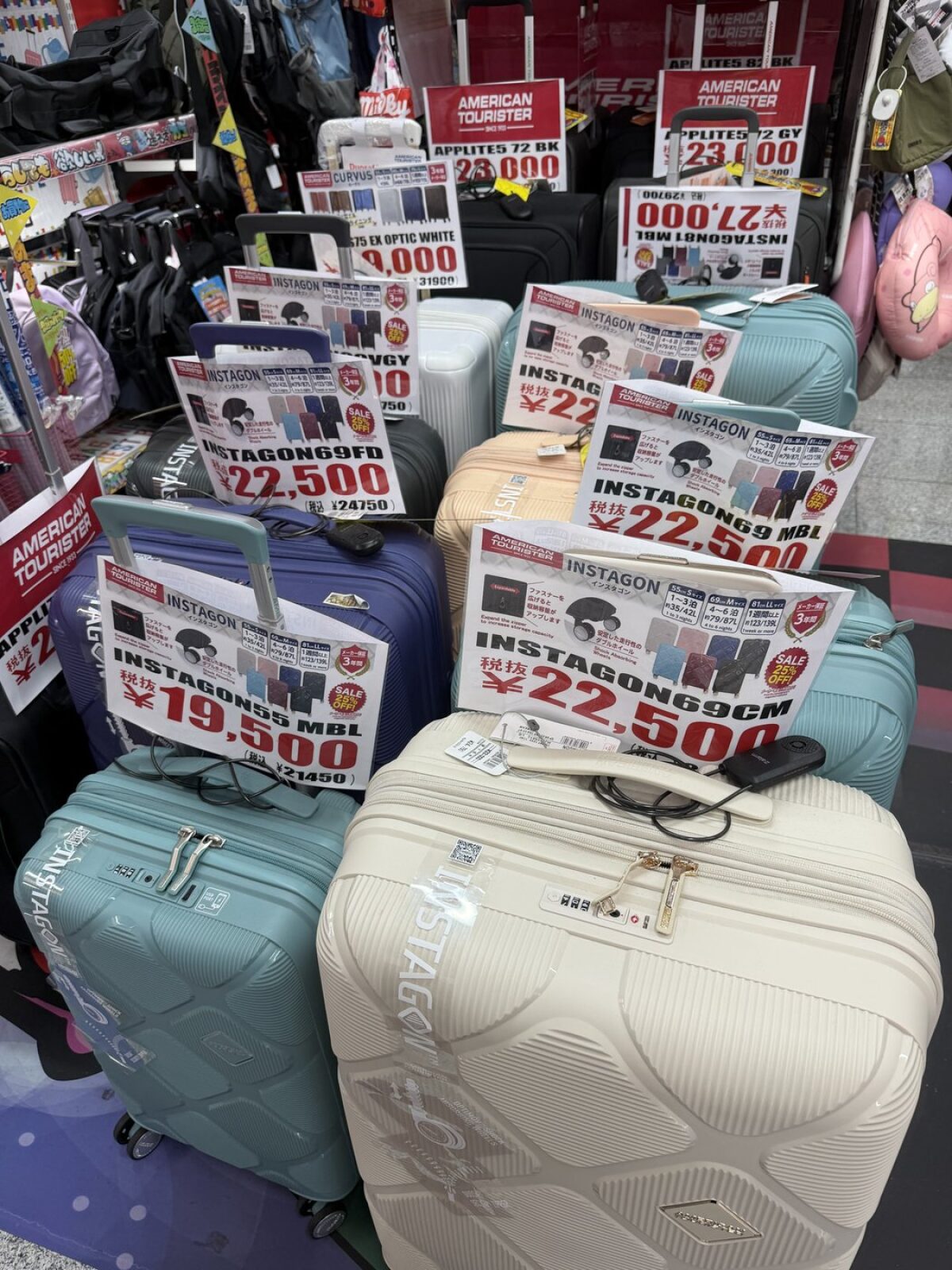 Suitcases stacked at Don Quijote with large handwritten price tags