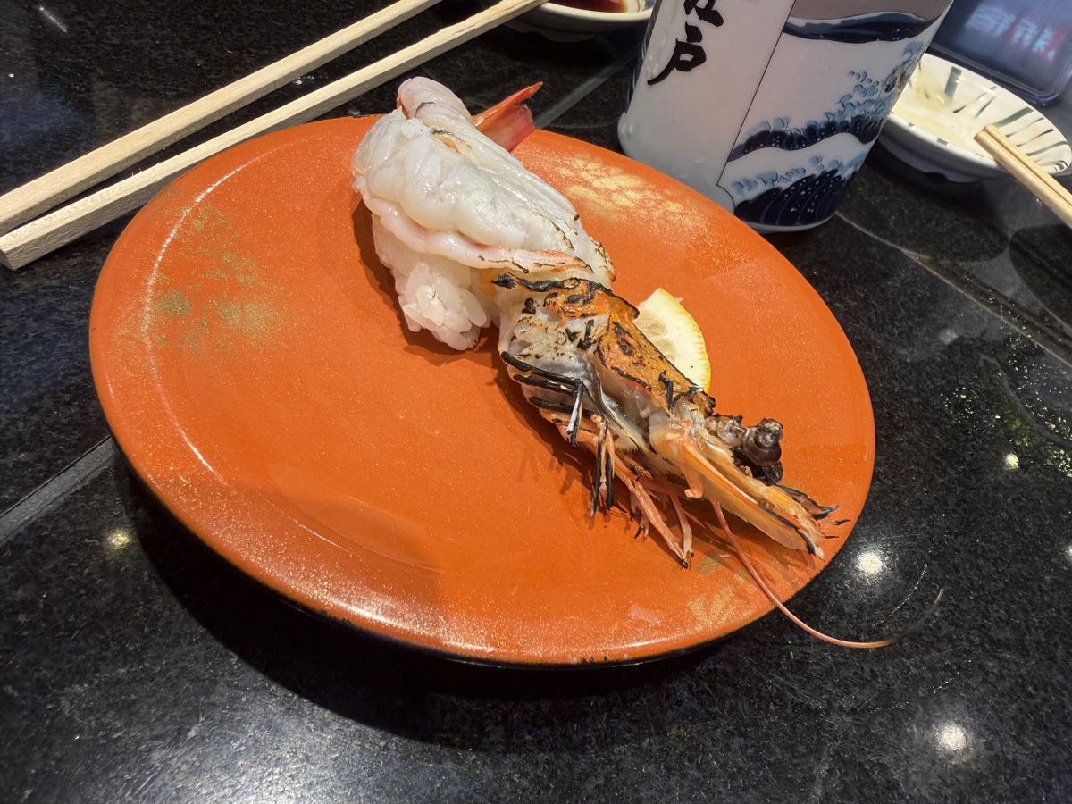 Giant shrimp sushi plate on orange dish at kaiten sushi Oedo Tokyo
