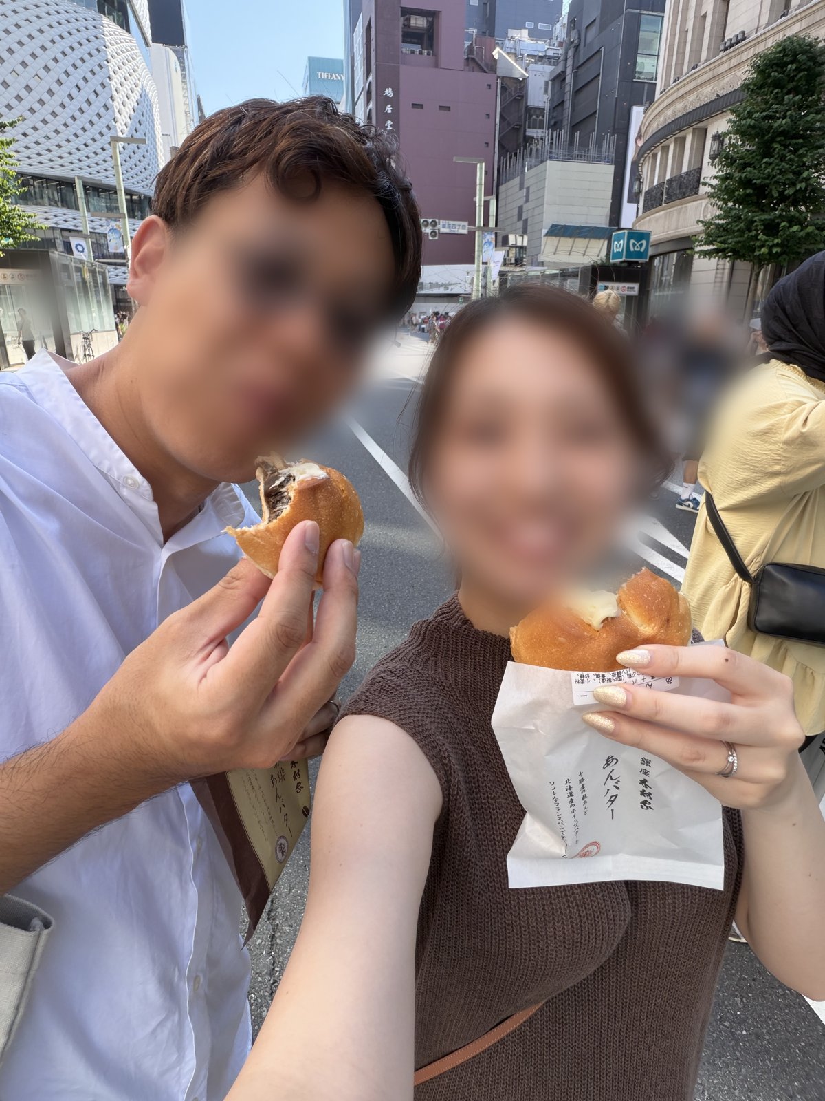 Couple eating Kimuraya anpan sweet buns on the Ginza pedestrian street