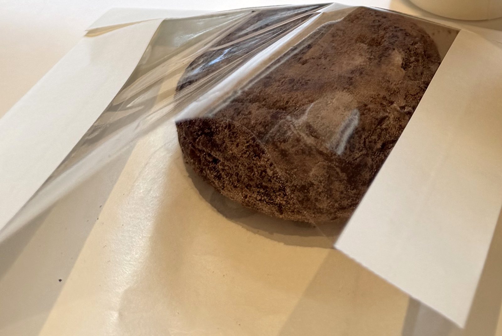 Cocoa-dusted chocolate nama-donut from im donut in its cellophane bag