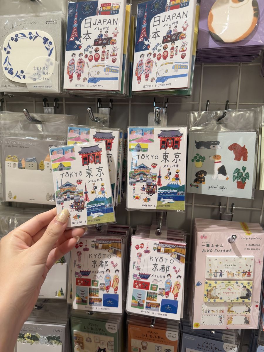 Hand holding JAPAN and TOKYO sticker packs at Ginza Itoya