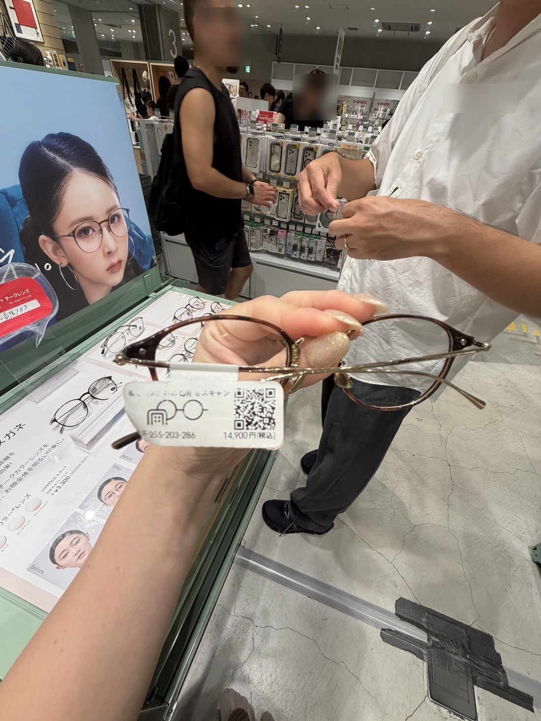 Hand holding glasses with a 14900 yen price tag at a Japanese eyewear shop