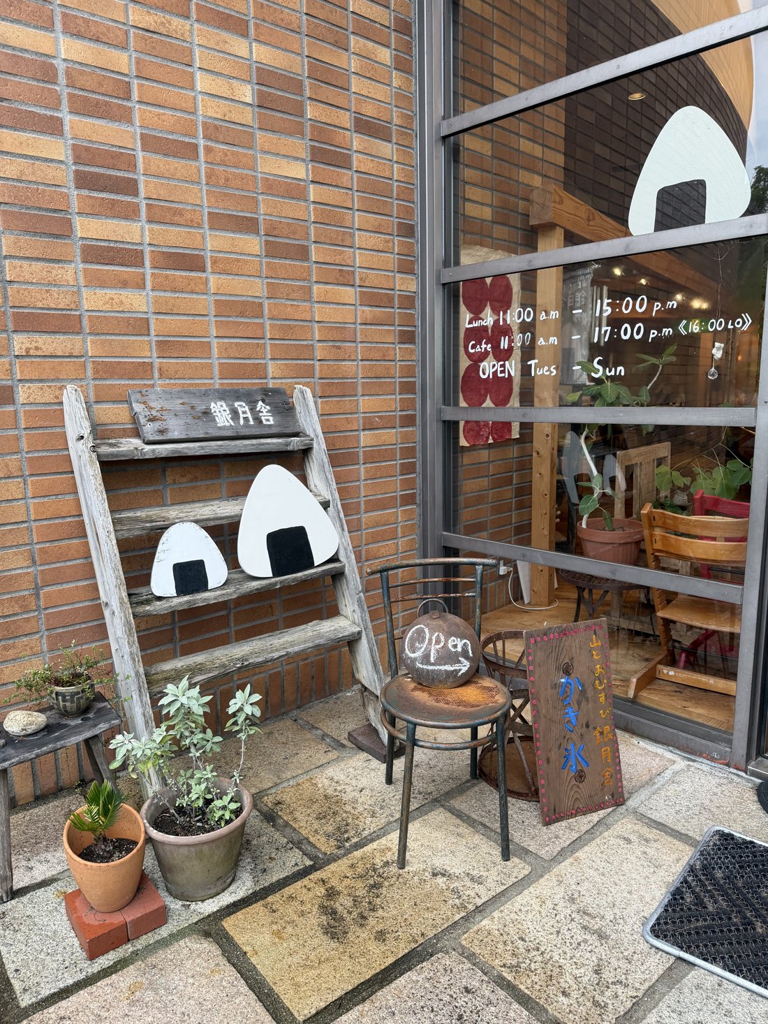 Small onigiri shop storefront with cute rice ball illustrations on the window