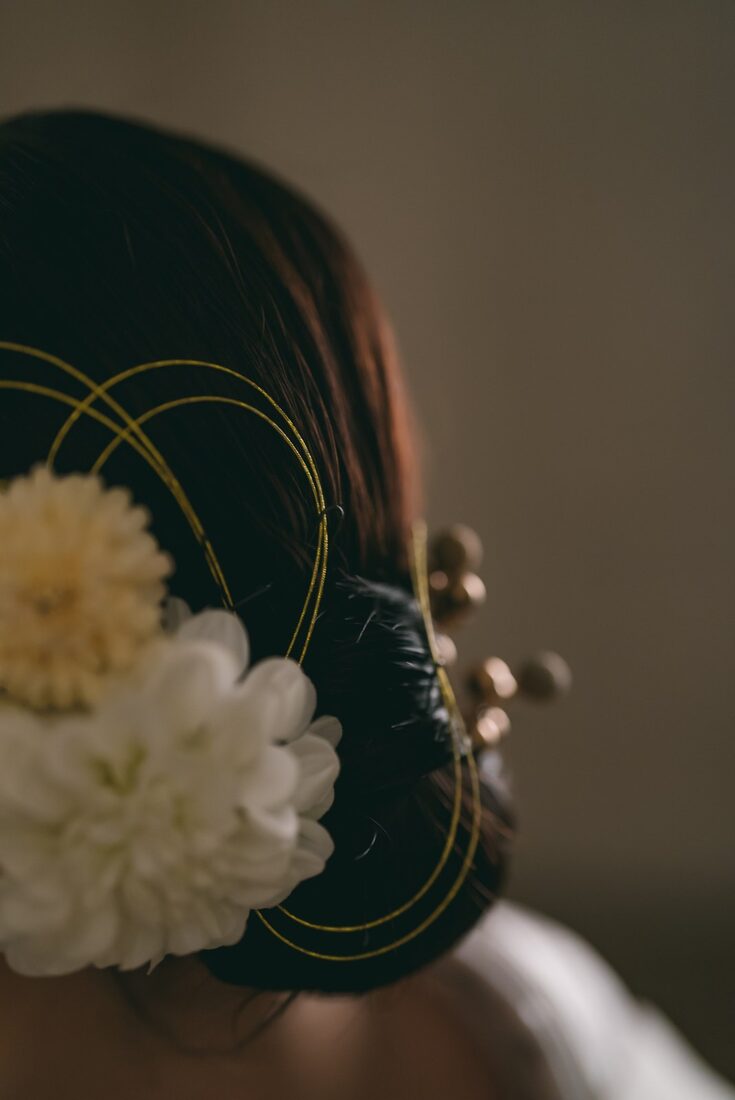 Chrysanthemum kanzashi hair ornament in a bridal updo, seen from behind