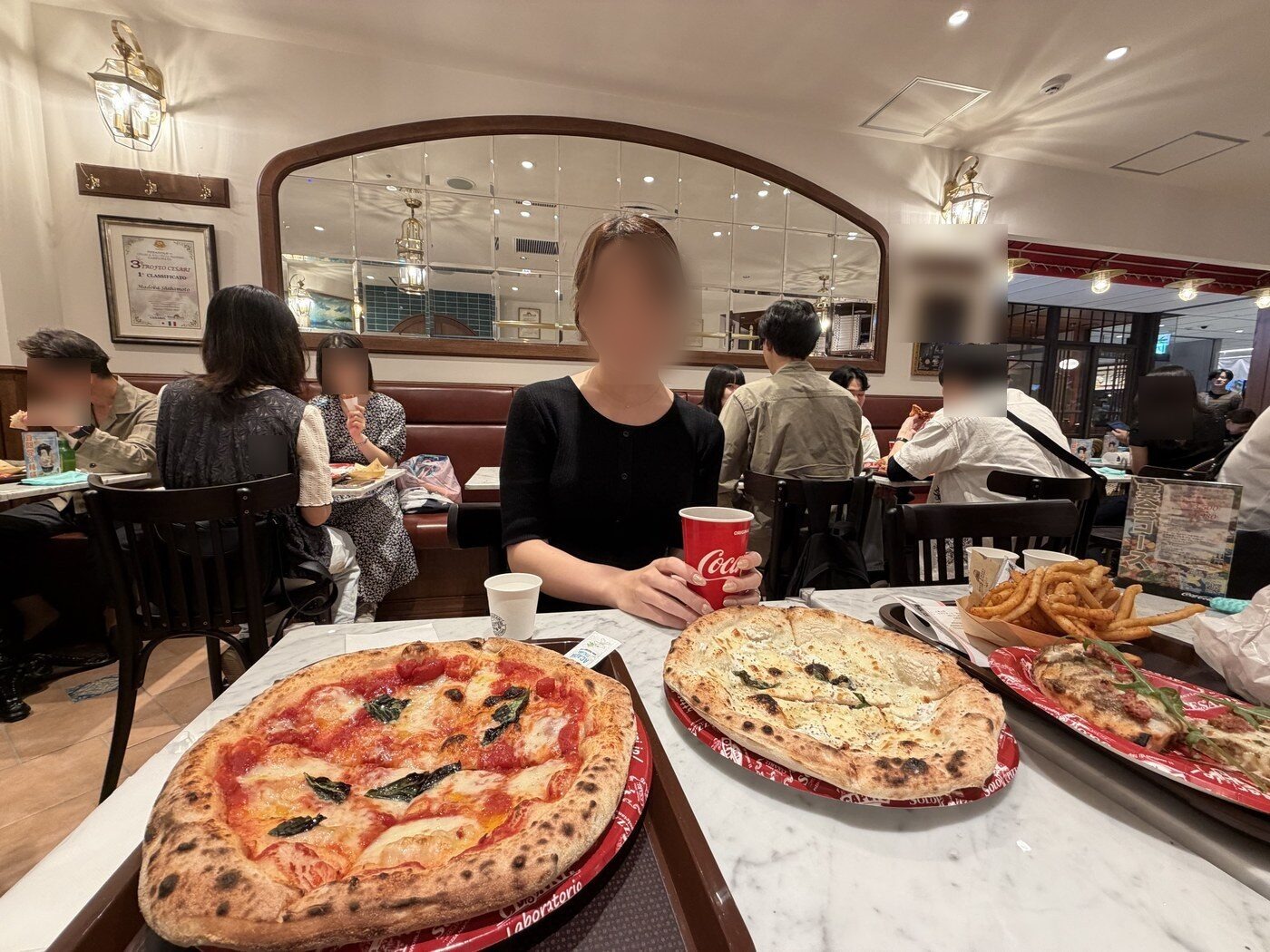 Neapolitan pizzas and fries on marble tables at a pizzeria in Nagoya
