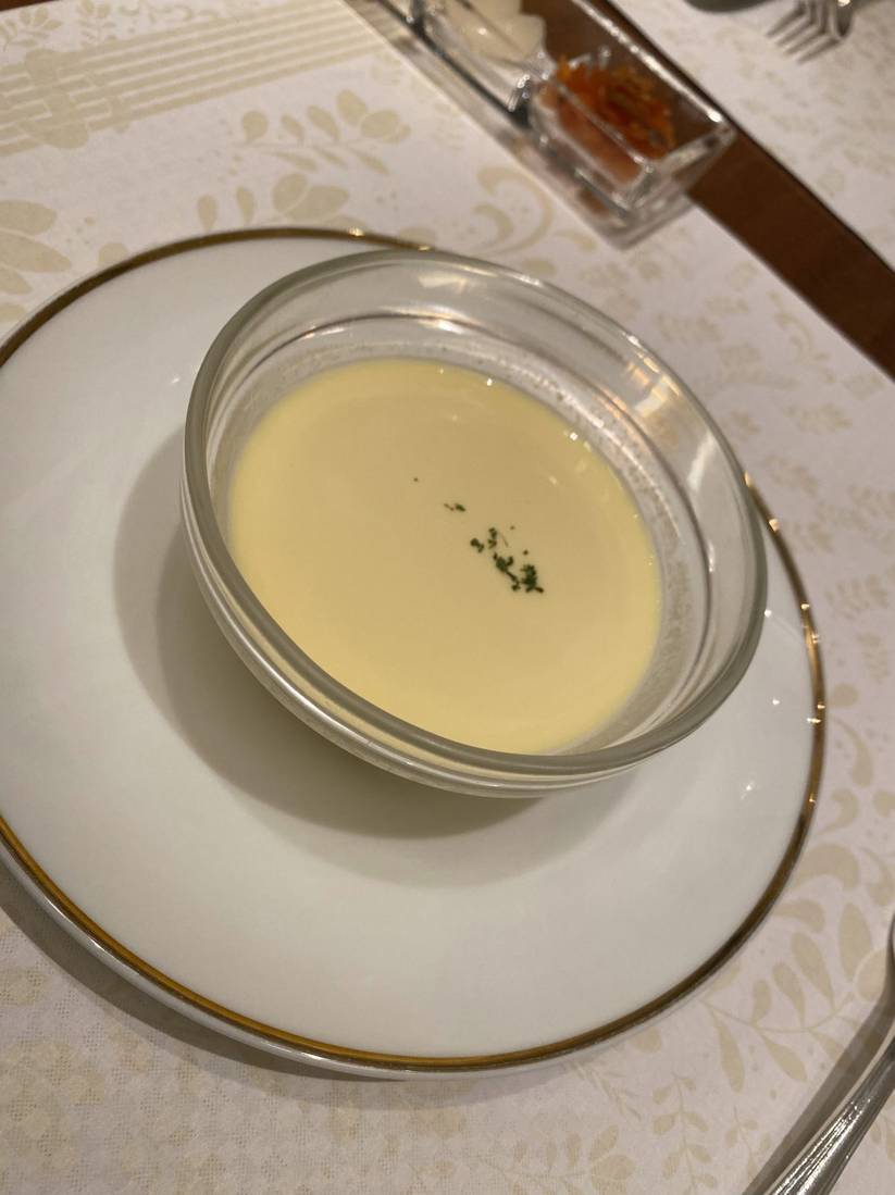 Cold consommé and sweetcorn cream soup in a gold-rimmed bowl