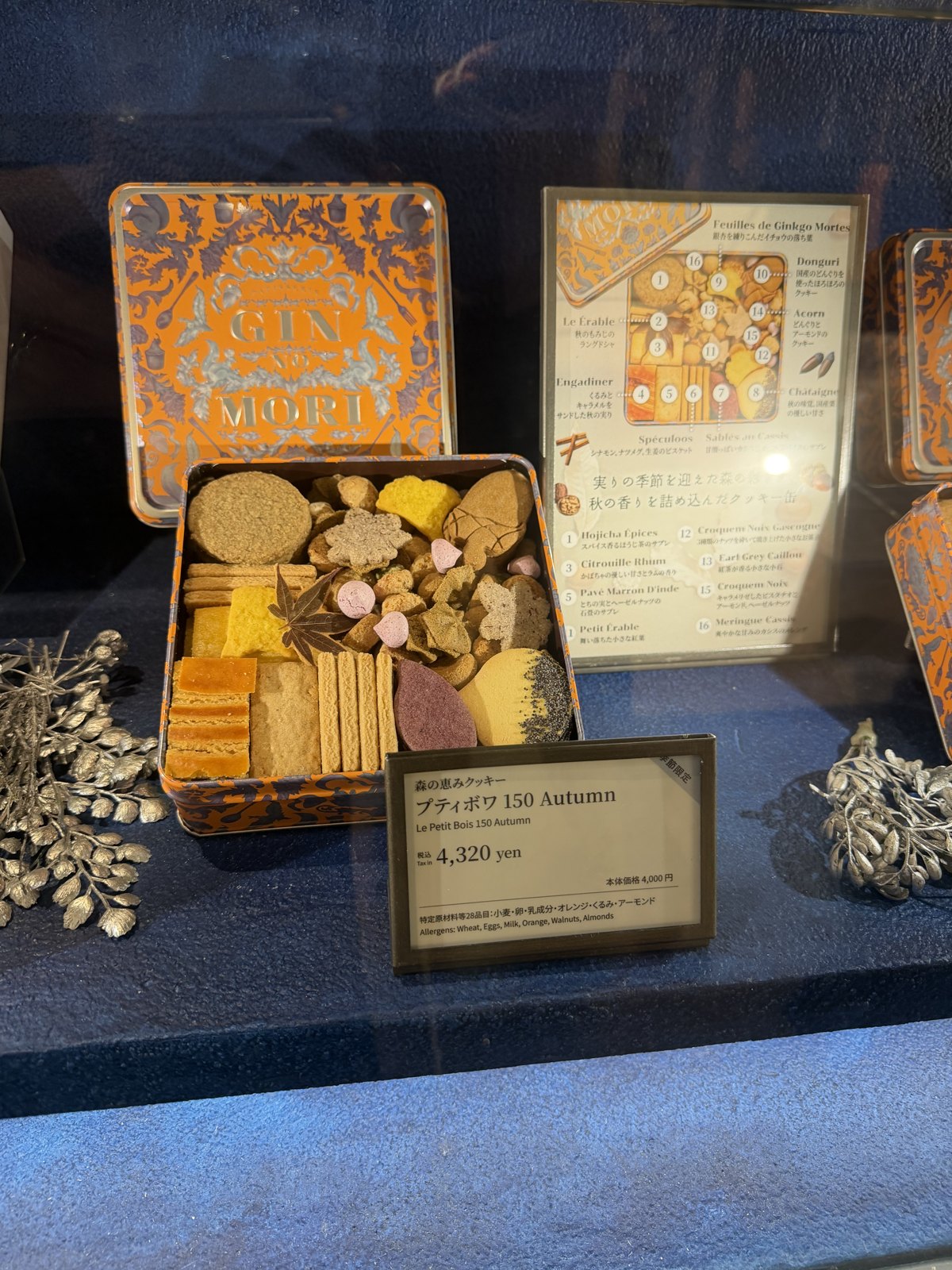 Open cookie tin with assorted cookies next to a price tag reading 4,320 yen