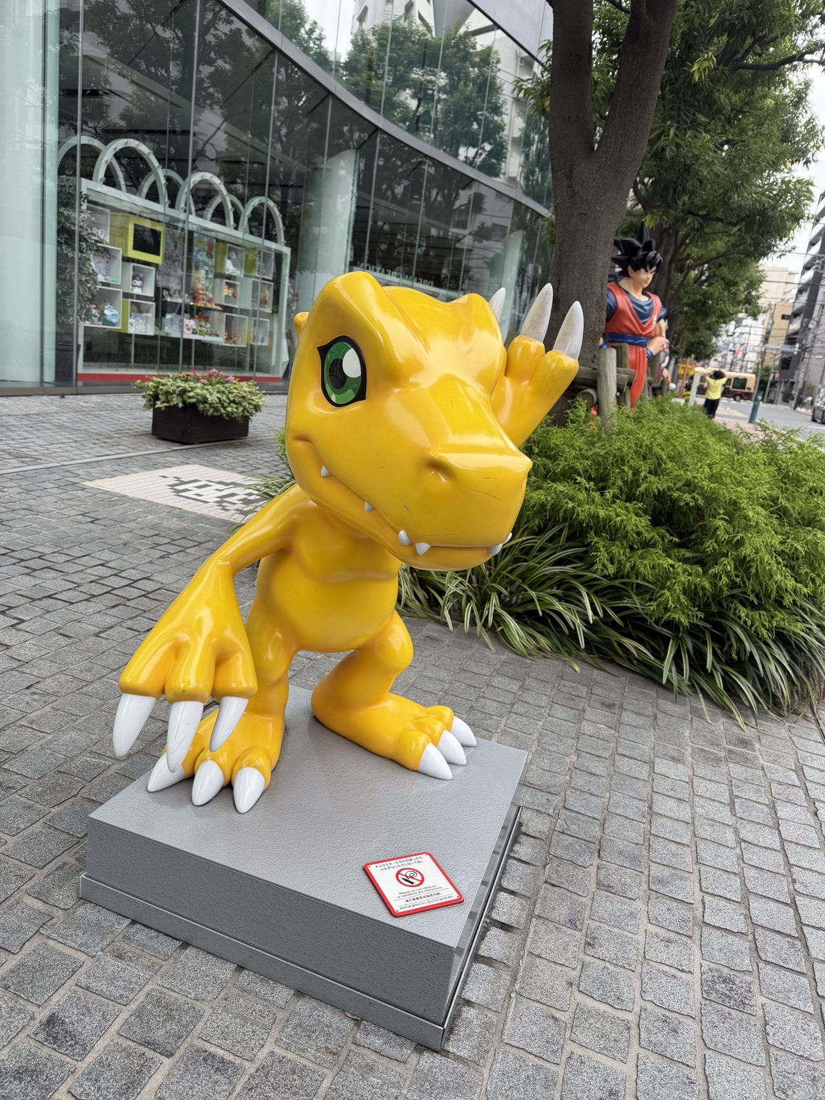 Yellow Agumon statue from Digimon on the pavement at the Bandai headquarters in Tokyo
