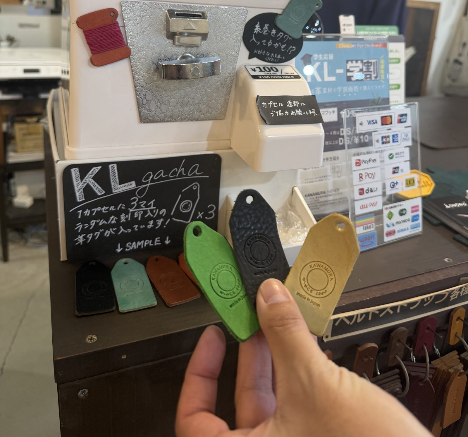 KL gacha capsule machine at Kawamura Leather in Kuramae with leather tags stamped Kawamura since 1932, 100 yen tax in