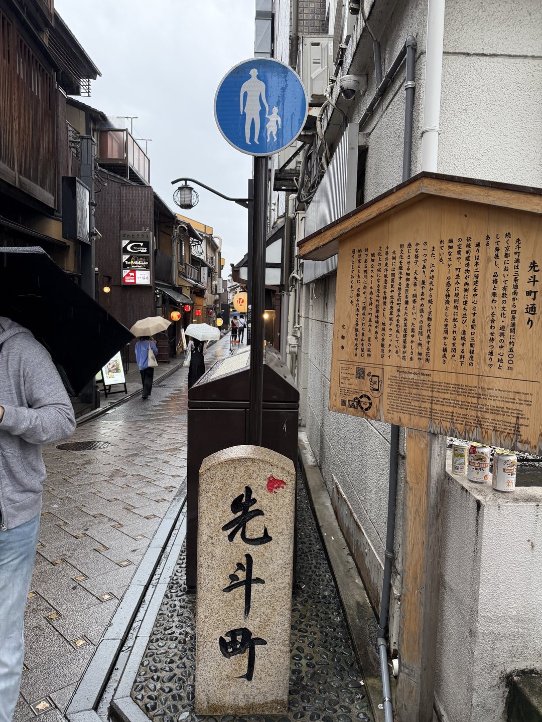 Pontocho lane in Kyoto on a rainy day, with the stone Pontocho marker in the foreground