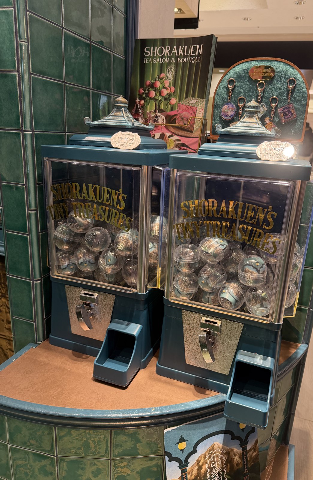 Two capsule toy machines labelled Shorakuen’s Tiny Treasures